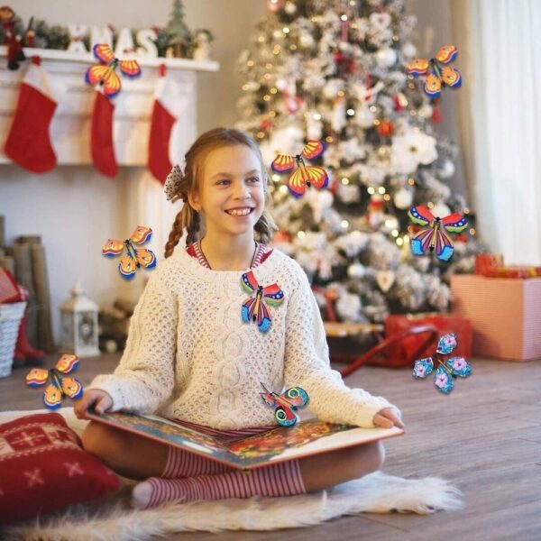 Una niña alegre sentada junto a un árbol de Navidad con un libro mágico, del que parecen volar coloridas mariposas, añadiendo un toque de encanto a la escena festiva.