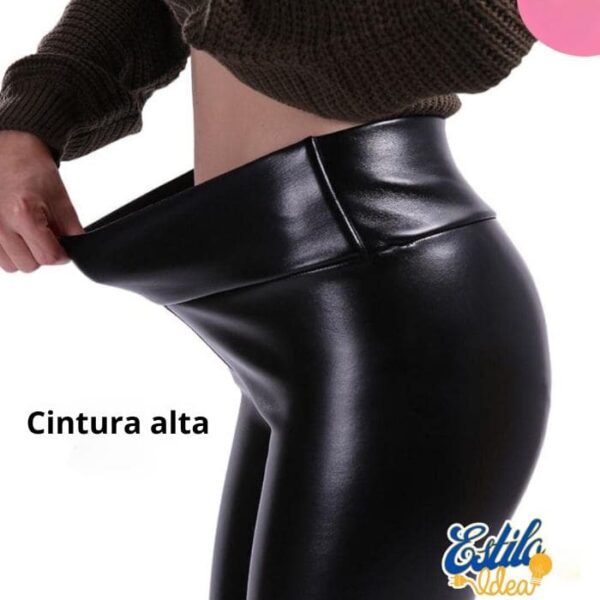 Mujer luciendo pantalones negros de piel sintética de cintura alta.